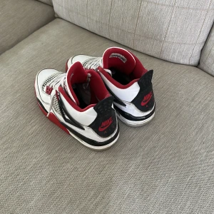 Nike Air Jordans vita och röda sneakers - Säljer ett par klassiska Nike Air Jordans sneakers i vitt, rött och svart. Jag har gått i de några gånger och tvättat de efter varje gång när jag har varit ute så de är i bra skick. De är 100% äkta men tyvärr har jag inte boxen från de kvar 