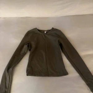 Mörkgrön långärmad tröja Nelly  - En basic mörkgrön långärmad tröja från Nelly . Tröjan har en enkel, rund halsringning och är figurnära i modellen. Tröjan är i storlek xs