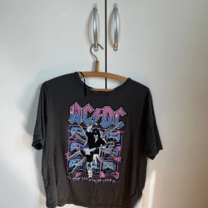 Svart AC/DC t-shirt med tryck - Cool svart t-shirt med stort färgglatt AC/DC-tryck. Från H&M , använd fåtal gånger ! 