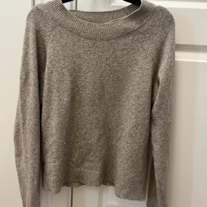 Beige stickad tröja från Vero Moda - Mysig beige stickad tröja från Vero Moda med rund halsringning och ribbade muddar. Perfekt för lager-på-lager och chill höst- eller vinterstil. Enkel och stilren design som funkar till allt.