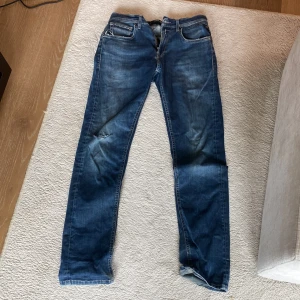 Blå Replay jeans, midwaist, straight - Säljer ett par blå jeans från Replay i modellen straight fit med klassisk femficksdesign. Jeansen har snygga slitningar och ett litet hål på ena benet för en extra edge. Sitter straght/slim