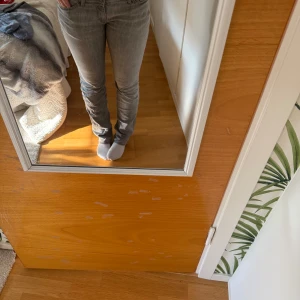 Grå Replay jeans straight fit - Säljer ett par grå jeans från Replay med klassisk femficksmodell och raka ben. Jeansen har normal passform och är tillverkade i mjukt denimtyg. Snyggt slitna detaljer och diskret röd söm på insidan av linningen.