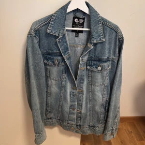 Cheap Monday klassisk jeansjacka S - Ljusblå jeansjacka från Cheap Monday i klassisk modell med två bröstfickor med knappar och snygga söm-detaljer. Jackan har en rak passform, krage och knäppning framtill. Använd en gång, som ny. Oversize passar M också. 