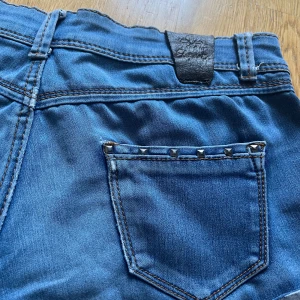 Blå jeansshorts  - Snygga blå jeansshorts från Sisters Point med coola silverfärgade nitar på fickorna fram och bak. Shorts med upprullade och råa benslut. 💕kontakta mig för midjemått.