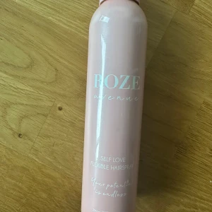 ROZE Avenue Self Love Hårspray - En snygg ljusrosa hårspray från ROZE Avenue med texten 'Self Love Flexible Hairspray'. Flaskan rymmer 250 ml och har en stilren, modern design. Perfekt för dig som vill ha en flexibel och fräsch finish på håret.
