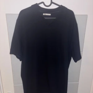 Marinblå pike från zara  - En stilren marinblå pike från Zara i storlek L. V ringad hals och korta ärmar, vilket ger en clean och modern look. Materialet känns mjukt och bekvämt mot huden.