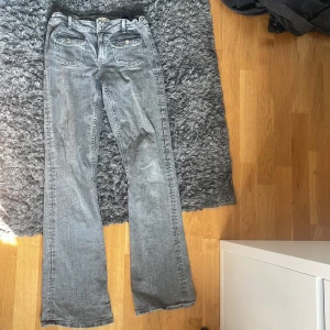 Grå bootcut jeans från Gina Young - Säljer ett par grå jeans från Gina Tricot i storlek 170. Modellen har bootcut-ben, klassiska fickor fram och bak. Dem är lite sönder längst ner men de är inget man tänker på tycker jag. Perfekta för dig som gillar en avslappnad men trendig look. Skriv om ni vill ha någon bild eller har några frågor❤️Ny pris 349 och säljer för 170