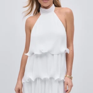 Vit halterneckklänning med volanger - Superfin vit klänning med halterneck och knyt i nacken. Slutsåld på Gina! Använd endast en gång. Intressekoll!!!💕💕