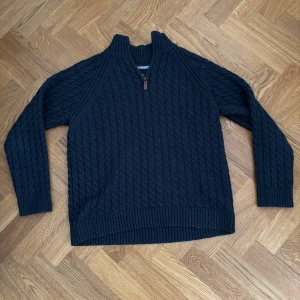 Mörkblå stickad tröja Bondelid M - Säljer en mörkblå stickad tröja från Bondelid i storlek M. Tröjan har ett snyggt kabelstickat mönster och  half zip-dragkedja, säljs då den blivit förliten för mig. Passar M/S, orginalpris: 799kr