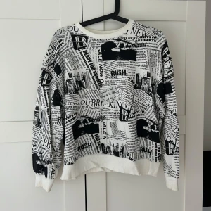 Bershka sweatshirt  - Använt bara fåtal gånger, svartvit sweatshirt från Bershka med tidningsinspirerat print över hela tröjan. Långärmad modell med ribbade muddar och rund hals. 