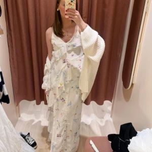 Långklänning från Gina Tricot - Superfin långklänning från Gina Tricot i vitt med blommigt mönster i pastellfärger. Klänningen har tunna axelband, v-ringning och volangdetaljer framtill. Perfekt för midsommar eller bara en sommardag!! Endast andävnd 1 gång!!❤️