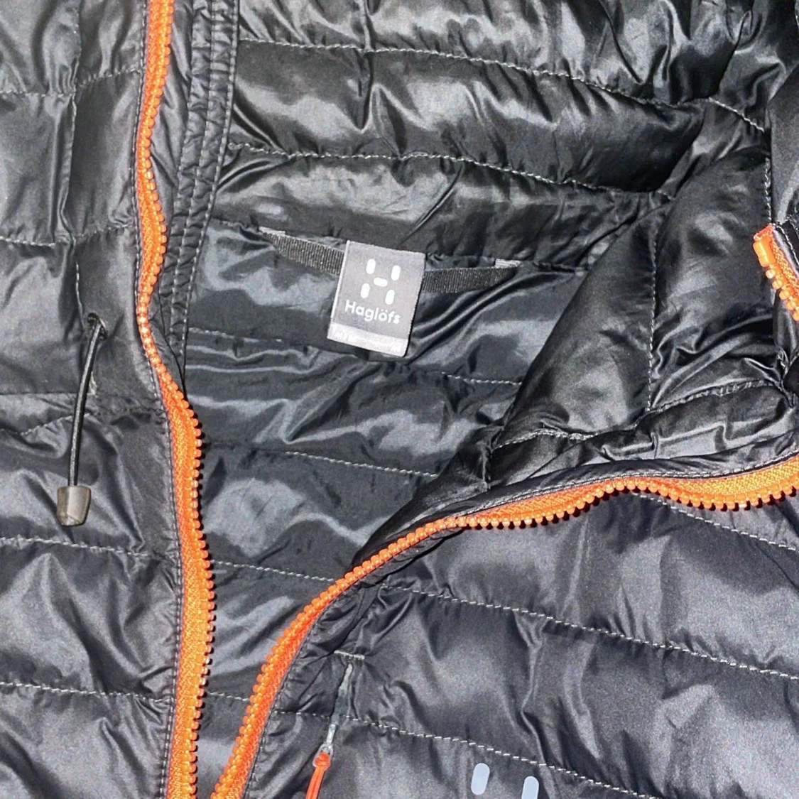 Svart dunjacka från Haglöfs med orange dragkedja - 2