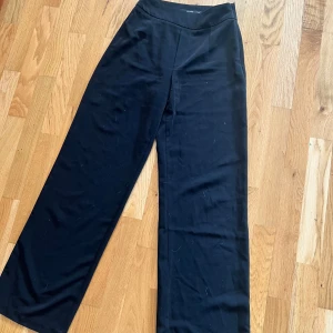 Svarta vida byxor från Bik Bok - Säljer ett par svarta, vida byxor från Bik Bok i storlek 36. Byxorna har hög midja och raka, breda ben och stretchigt material.                                OBS!! Lite ludd på 