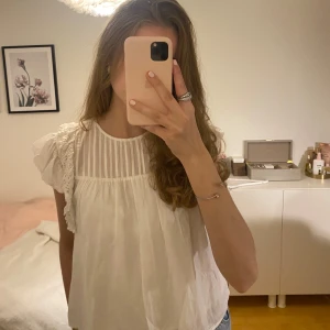 Vit blus med spetsdetaljer från & Other Stories - Säljer denna fina,vita volang blusen från & Other Stories. Plagget är i bra skick och passar perfekt till sommaren!💕