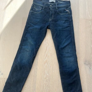 Mörkblå Replay Anbass jeans - Replay jeans i slim fit modell anbass, små märken som syns på bilderna. 
