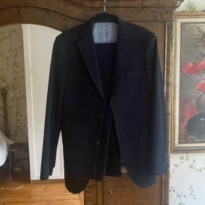 Cavaliere kostym - Säljer en stilren mörkblå kavaj från Cavaliere i slim fit-modell. Kavajen har två knappar framtill och klassiska slag. Perfekt för bal eller festliga tillfällen. Byxor också. Ny pris är mellan 4000-10000. Storlek 44=XS/S