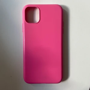 Rosa silikonfodral till iPhone 11 från Holdit - Säljer ett snyggt och stilrent mobilskal i starkt rosa färg från Holdit, anpassat för iPhone 11. Skalets material är mjukt silikon som ger ett bra grepp och skydd till mobilen. Endast använd några gånger, men skalet har en liten defekt i kanten.💕