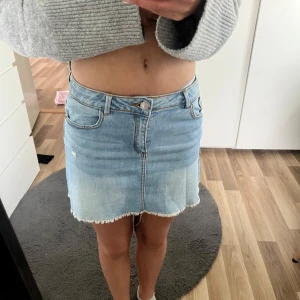 Ljusblå jeanskjol från Zara - Säljer en ljusblå jeanskjol från Zara med rå kant nertill och klassiska fickor fram och bak. Kjolen har normal passform och stängs med knapp och dragkedja. Perfekt för en avslappnad stil. Sälkee eftersom att jag har bytt stil!