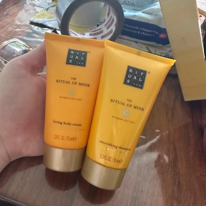 Rituals The Ritual of Mehr body cream och shampoo - Säljer två produkter från Rituals The Ritual of Mehr-serien: en loving body cream med doft av söt apelsin och cederträ (70 ml) samt ett nourishing shampoo med arganolja och shikakai (70 ml). Båda i praktiska orange tuber med guldfärgade lock.