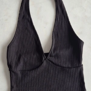Svart ribbad halterneck topp från Bershka - Säljer en svart ribbad halterneck topp från Bershka. Materialet är stretchigt och bekvämt. Använd två gånger 