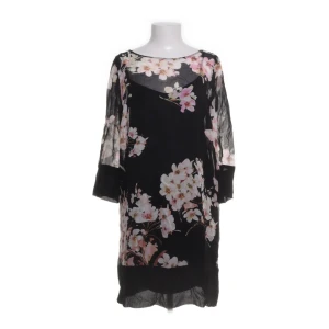 Klänning från Twinset - Säljer en svart klänning från Twinset med vackert blommigt mönster i rosa och vitt. Klänningen har trekvartsärm och är tillverkad i ett lätt, transparent material som ger en luftig känsla. Perfekt för dig som vill ha en feminin och stilren look. Det står str 44 (IT), men klänningen är S (36 - 38) i verkligheten. 