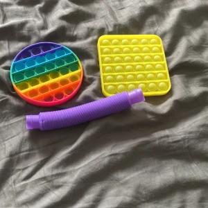3 fidget toys - Bilden visar två pop it-leksaker och ett flexibelt rör