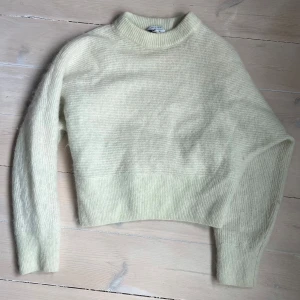Ljusgrön stickad tröja från & Other Stories - Supermjuk och fluffig ljusgul stickad tröja från & Other Stories. Tröjan har en hög hals och är i en lite kortare modell. Jättefin ljusgrön färg. Står M men är mer som S. 