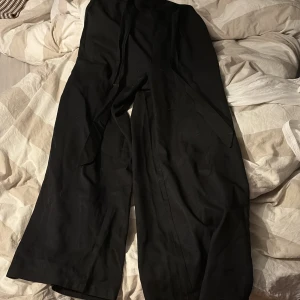Svarta vida byxor från SHEIN - Svarta byxor från SHEIN med breda ben och resår i midjan. Byxorna har en lös och bekväm passform, perfekta för en avslappnad stil. Tillverkade i ett mjukt och lätt material som känns skönt mot huden. Dom är lite smutsiga nu men kommer tvättas! Har använt dom några gånger för länge sedan. Inte använt på några år nu.