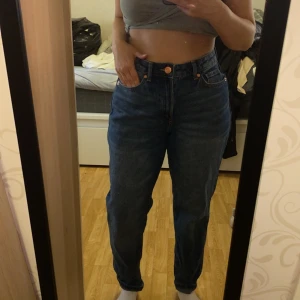 Levis 501 blå jeans - Klassiska blå Levis 501 jeans med hög midja och raka ben. Jeansen har fem fickor, knappgylf och en tidlös passform som funkar till allt. Perfekta för dig som gillar en avslappnad men ändå snygg stil.