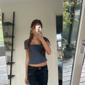 Blå ribbad croppad topp från H&M - Säljer en skitsnygg blå croppad topp från hm med ribbad struktur och fyrkantig urringning. Toppen har korta ärmar och är perfekt för en avslappnad och trendig stil. Passar särskilt snyggt till typ jeans enligt miiiig!