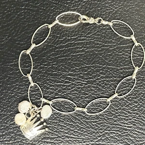 Silverfärgat armband med äkta sötvattenspärlor och kronberlock från Pearls for Girls - Fint armband från Pearls for Girls med tre oregelbundna sötvattenspärlor och berlock i form av en liten krona. Kedja i silverfärgad metall med karbinlås. Ca 21 cm långt och 0,9 cm brett. Ett lättburet smycke i mycket fint skick – passar perfekt som vardagsaccessoar eller present. Prutning accepteras ej, men jag erbjuder rabatt vid köp av flera saker. Rensar garderoben – kika gärna på mina andra annonser också!  ⸻ 
