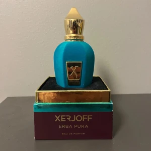 Xerjoff Erba Pura Eau de Parfum - Lyxig parfym från Xerjoff, Erba Pura, i en elegant turkos flaska med gulddetaljer. Även den gamla velvet som ej tillverkas längre! Flaskan rymmer 50 ml och kommer i en stilren förpackning. Perfekt för den som söker en unik och sofistikerad doft. Ungefär 80% kvar. Säg till om ni har några frågor eller om ni vill ha mer bilder!