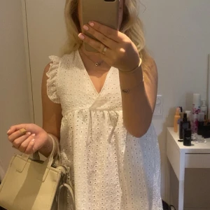 Vit broderad klänning med volang - Säljer en söt vit klänning med broderade detaljer och volang. Kommer ifrån Bubbleroom och är i storlek S. Perfekt till sommaren 