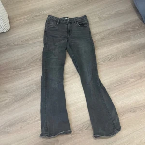 Grå bootcut jeans - Säljer ett par gråa bootcut jeans. Jeansen är utsvängda nertill och är Lågmidjade. 