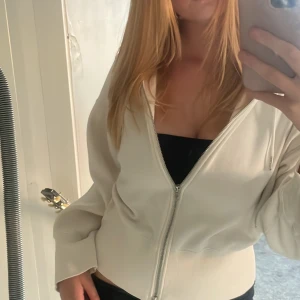 Vit zip-hoodie med dragsko - Säljer en vit hoodie från Stockholm LM i storlek M som inte kommer till användning, endast provad och aldrig använd. Skön att ha på sig, dragkedjan funkar bra. Pris kan diskuteras 