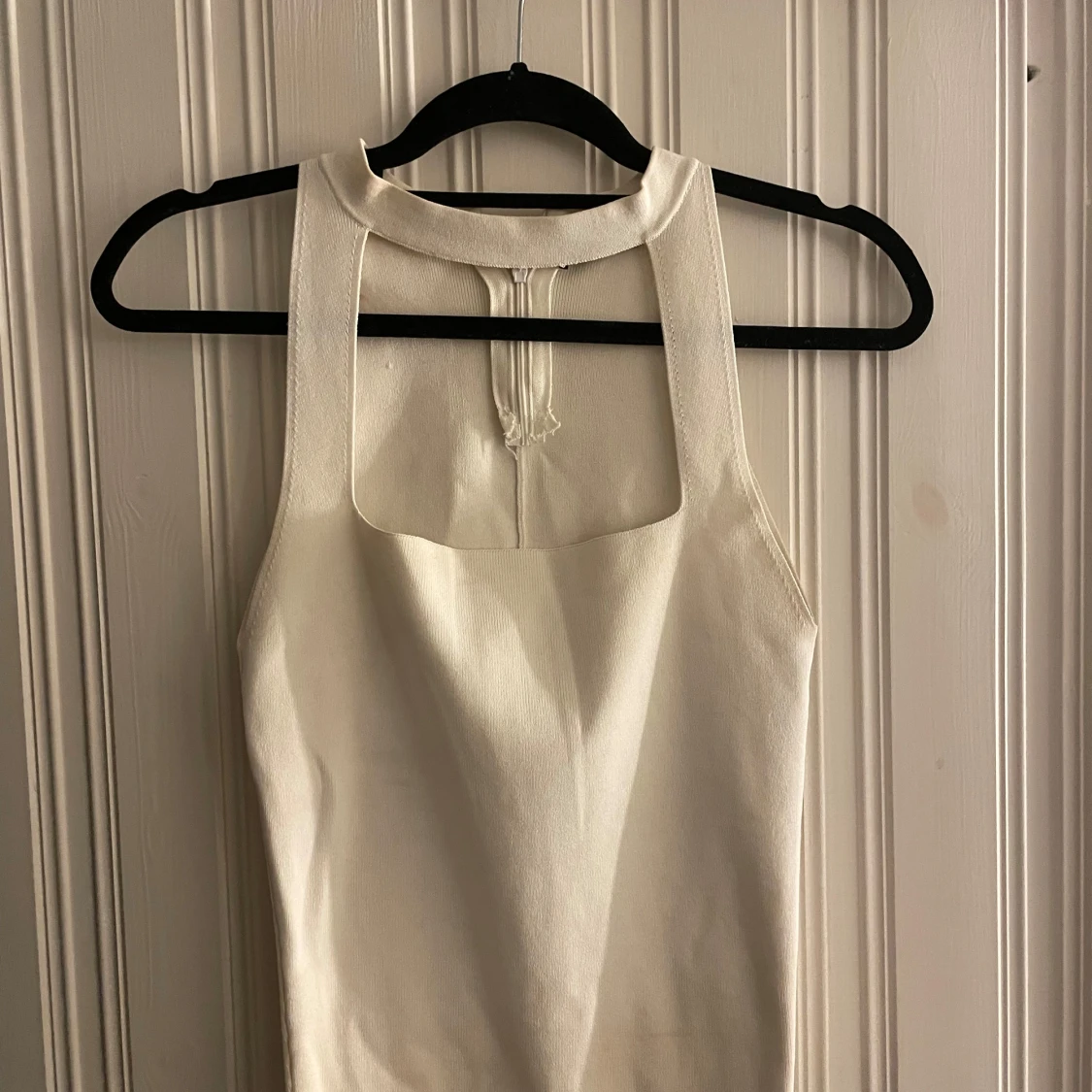 Vit ärmlös linnetopp med hög hals