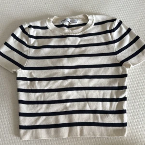 Randig kortärmad tröja från Zara - Superfräsch kortärmad tröja från Zara i vitt med svarta horisontella ränder. Tröjan har rund halsringning och är gjord i mjuk bomull.