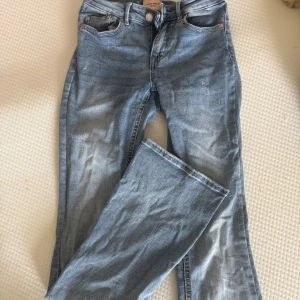 Bootcut jeans från Vero Moda - Ljusblå bootcut jeans från Vero Moda med klassisk femficksdesign och hög midja. Jeansen är i mjuk denim med mycket stretch och har en snygg utsvängd passform nertill. Storlek XS längd 34