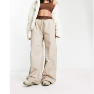 Beiga wide byxor med snörning - Säljer ett par beiga wide byxor med snörning i midjan. Byxorna har en loose passform och är riktigt sköna och trendiga. Perfekta för dig som gillar avslappnad stil och vill ha något som sticker ut lite extra.