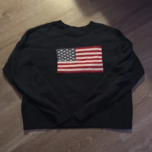 Mörkblå stickad tröja med USA-flagga Hollister - Mörkblå stickad tröja från Hollister i storlek XS. Tröjan har en stor amerikansk flagga framtill och ribbade muddar vid hals, ärmslut och nederkant!💕