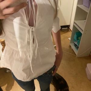 Vit blus med knyt och volang - Säljer den här toppen❤️Har inte använt den så många gånger❤️Storlek xxs från H&M färg vit❤️
