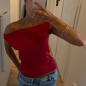 Röd offshoulder topp - Snygg asymmetrisk röd offshoulder topp med en axel bar. Toppens material är mjukt och stretchigt 🩷