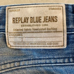 Blå jeans från Replay - Snygga blå jeans från Replay med klassisk femficksdesign och subtila slitningar. Dom är i storlek 30 i midjan och finns en liten skavank precis under gylfen men ingen man märker av.