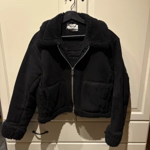 Svart teddyjacka från Weekday - Säljer en snygg svart teddyjacka från Weekday med dragkedja framtill. Storlek S. Jackan har en mysig krage och muddar i teddy-material samt två praktiska fickor. I bra men använt skick. Nypris 1100kr! Hör av er för fler bilder/frågor!💗