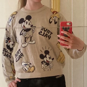 Beige Disney-tröja från H&M - Säljer en beige tröja från H&M med Disney-motiv av Musse Pigg och Kalle Anka. Tröjan har texten 'True Pals' och är långärmad med en normal passform. Perfekt för alla Disney-fans! 🐭🦆Har använts max 3 ggr men har små fläckar som syns om man kollar nära.