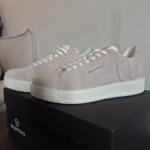 Beige sneakers från Valentino - Helt nya, beige sneakers från Valentino i mocka med vit sula och snörning. Oanvända i låda. Perfekta & stilrena skor med diskret logga på sidan. Dessa skor är super bekväma och säljs på grund av att de är för stora för mig.