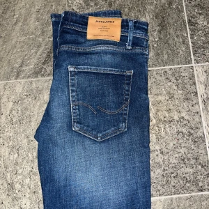 Blå jeans från Jack & Jones - Skitsnygga blå jeans från Jack & Jones säljes. Modellen kallas för Mike och jeansen har en ganska Regular/straight passform. Perfekta för en avslappnad stil. Storleken är 29/30.