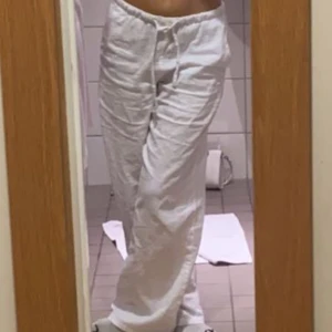 Vita linnebyxor - Säljer ett par vita linnebyxor med avslappnad passform. Byxorna har en elastisk midja för extra komfort och är perfekta för varma dagar. De är långa och har en luftig känsla. Dem är ifrån Gina Young men passar xxs 