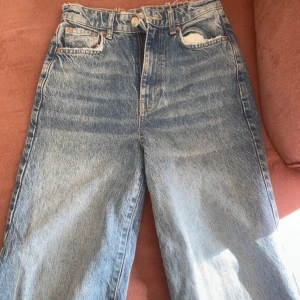 Blå jeans med vida ben  - Säljer ett par blå jeans med hög midja och vida ben. Storlek 32. Perfekta för en casual look.