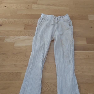 Beige randiga linnebyxor med snörning - Säljer ett par bekväma beige byxor med randigt mönster och snörning i midjan. Perfekta för en avslappnad stil. Köp gärna!❤️